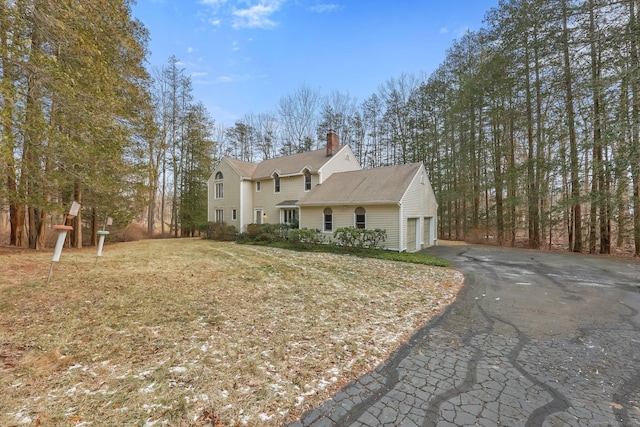 view of front of property with a garage and a front lawn