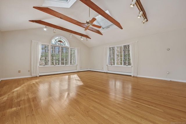 unfurnished living room featuring ceiling fan, light hardwood / wood-style floors, and vaulted ceiling with skylight