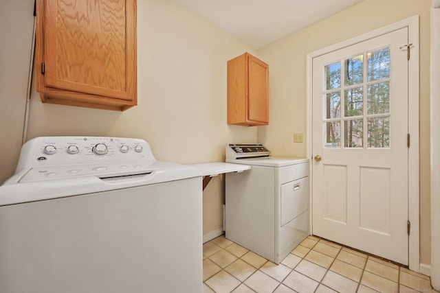 washroom featuring cabinets, separate washer and dryer, and light tile patterned floors