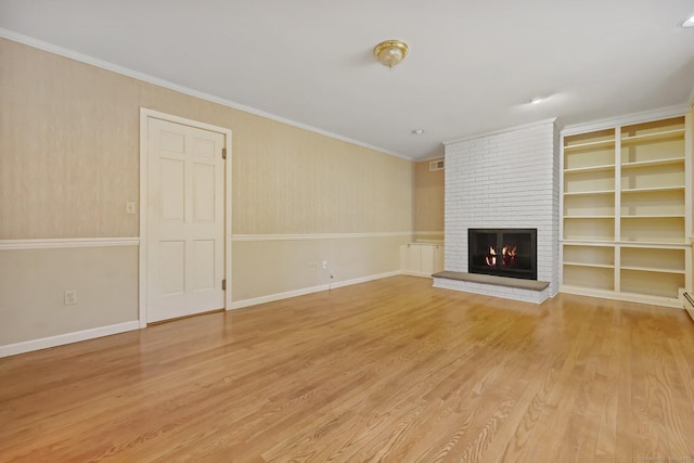 unfurnished living room featuring crown molding, a fireplace, built in shelves, and hardwood / wood-style flooring