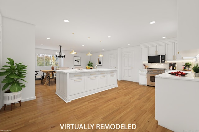 kitchen featuring high end stainless steel range, light wood-type flooring, a kitchen island, pendant lighting, and white cabinets