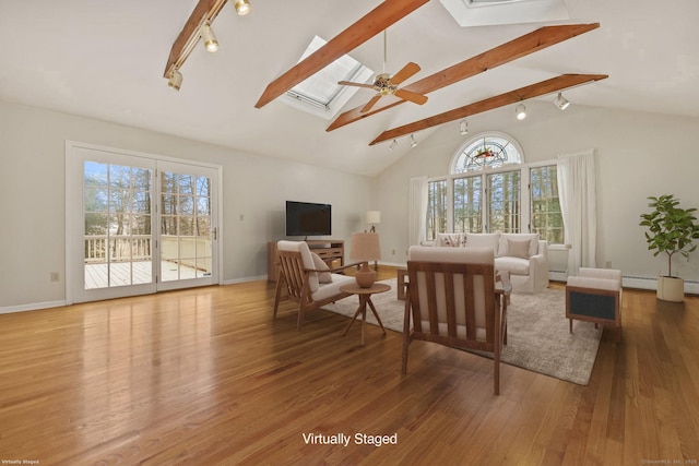 living room featuring hardwood / wood-style flooring, a healthy amount of sunlight, and lofted ceiling with skylight