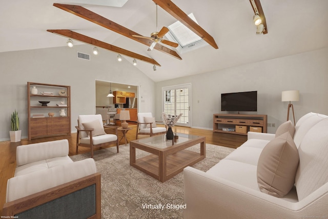 living room with high vaulted ceiling, a skylight, beamed ceiling, hardwood / wood-style flooring, and ceiling fan