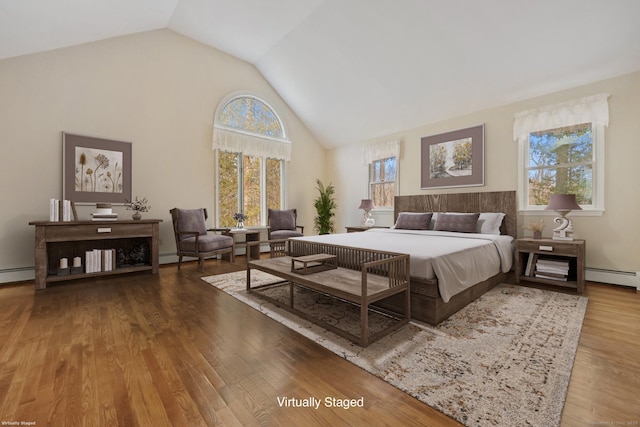 bedroom featuring wood-type flooring, vaulted ceiling, and a baseboard heating unit