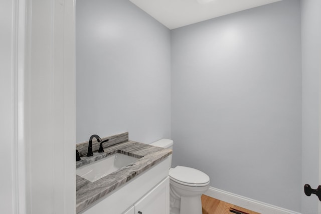 629 Hartford Rd, Salem, CT 06420 - half bathroom with wood finished floors, toilet, baseboards, and vanity