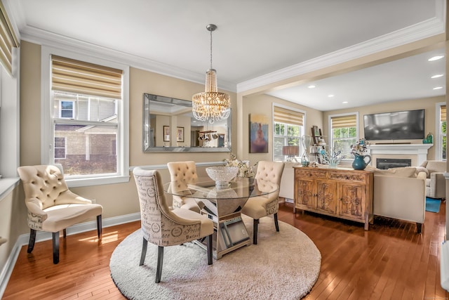 dining area featuring dark hardwood / wood-style flooring, a notable chandelier, and ornamental molding