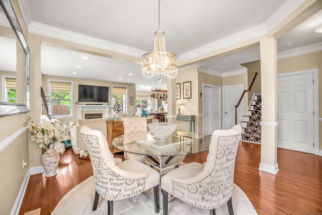 dining area featuring hardwood / wood-style flooring, ornamental molding, and a chandelier