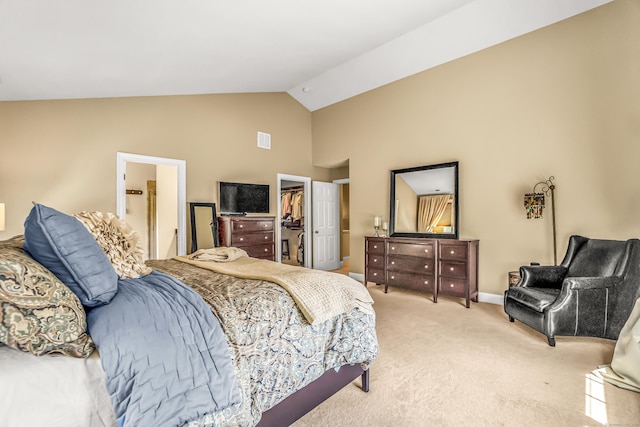 carpeted bedroom featuring ensuite bath, a spacious closet, a closet, and lofted ceiling