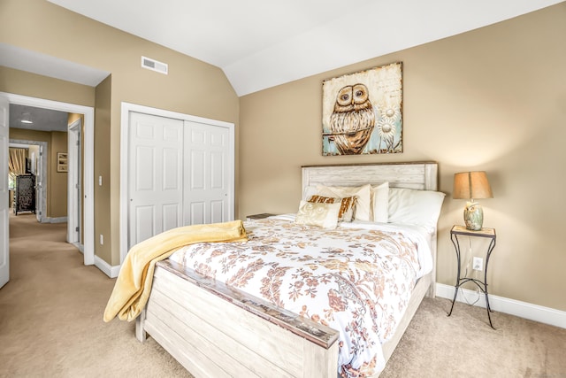 bedroom with light carpet, a closet, and lofted ceiling