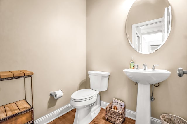 bathroom with toilet and wood-type flooring