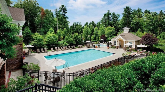 view of pool featuring an outbuilding and a patio