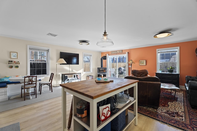 dining area featuring light hardwood / wood-style floors and crown molding