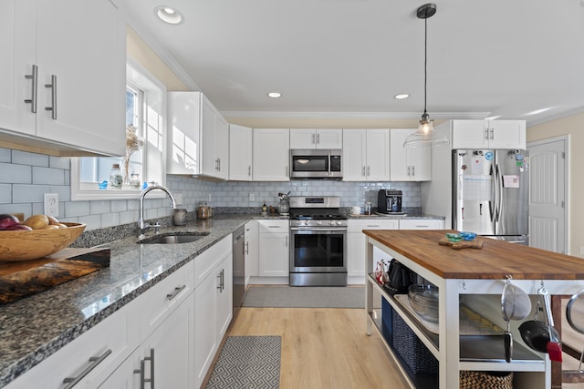 kitchen with butcher block counters, sink, white cabinets, and appliances with stainless steel finishes