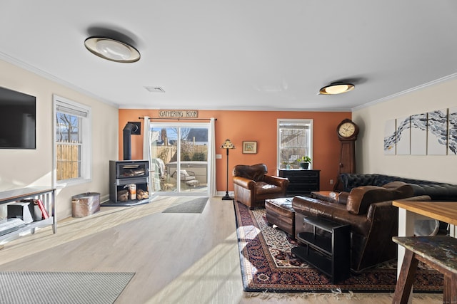 living room with plenty of natural light, light hardwood / wood-style floors, and crown molding