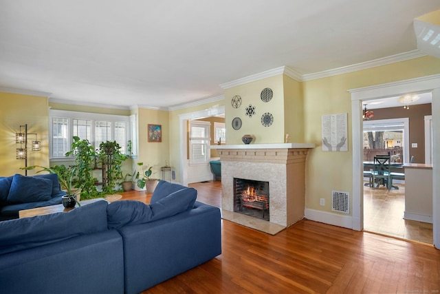 living room featuring ornamental molding and a brick fireplace