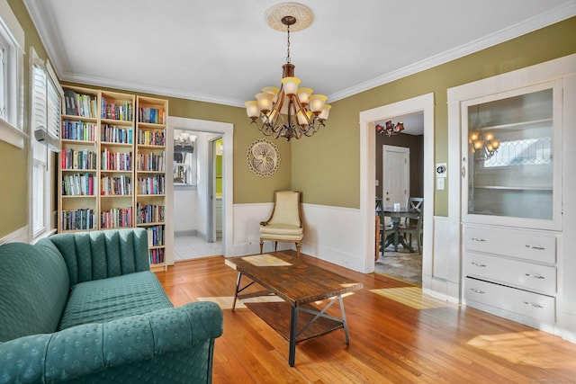 living area featuring plenty of natural light, light hardwood / wood-style floors, and an inviting chandelier