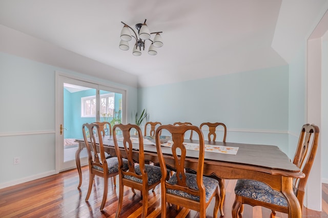 dining room featuring a chandelier, hardwood / wood-style floors, and lofted ceiling