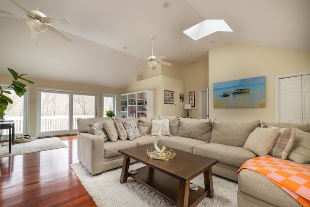 living room featuring a skylight, ceiling fan, high vaulted ceiling, and hardwood / wood-style flooring