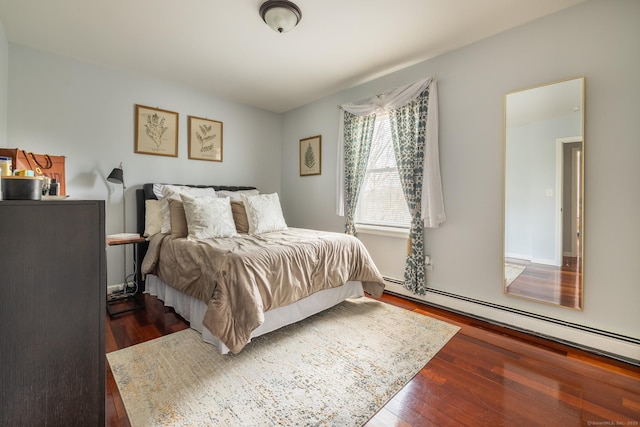 bedroom featuring dark hardwood / wood-style floors and a baseboard heating unit