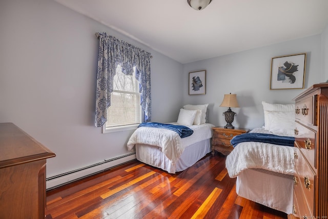 bedroom with dark hardwood / wood-style flooring and a baseboard heating unit