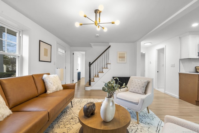 living room with light wood-type flooring and an inviting chandelier