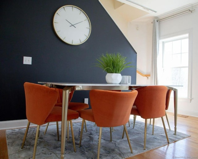 dining space with hardwood / wood-style floors, plenty of natural light, and ornamental molding