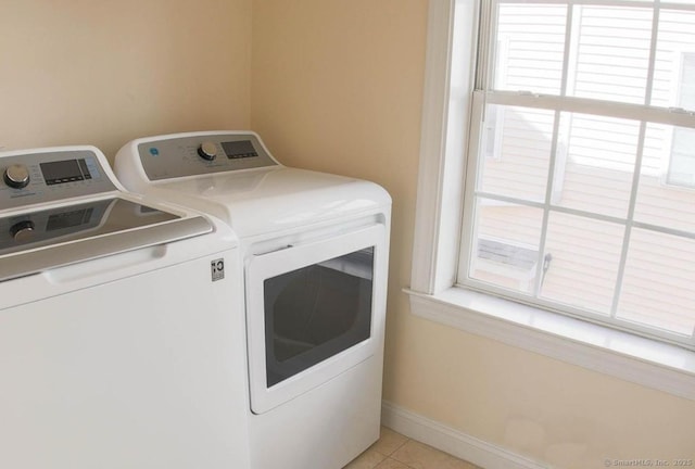 laundry area featuring washing machine and dryer and light tile patterned floors