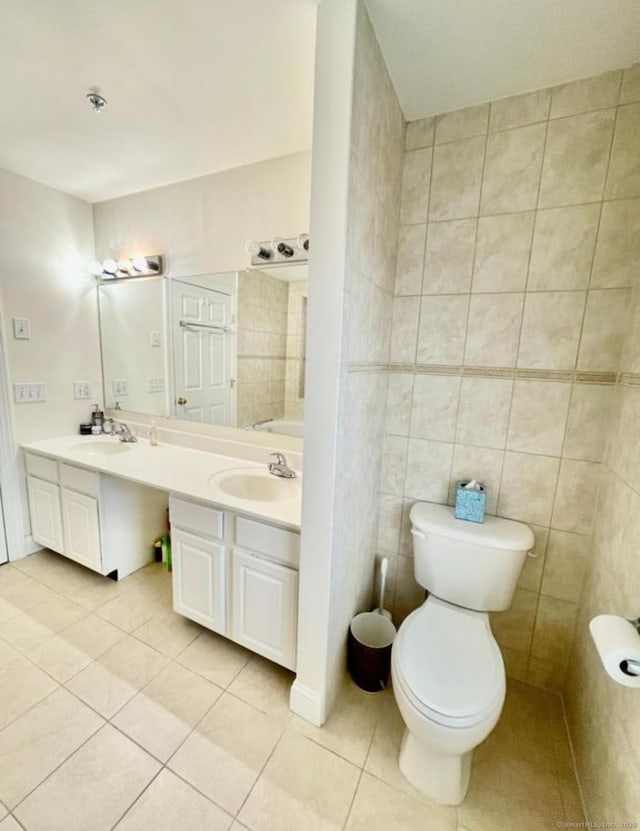 bathroom with tile patterned floors, vanity, tile walls, and toilet