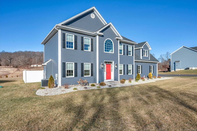 view of front of house with cooling unit and a front lawn