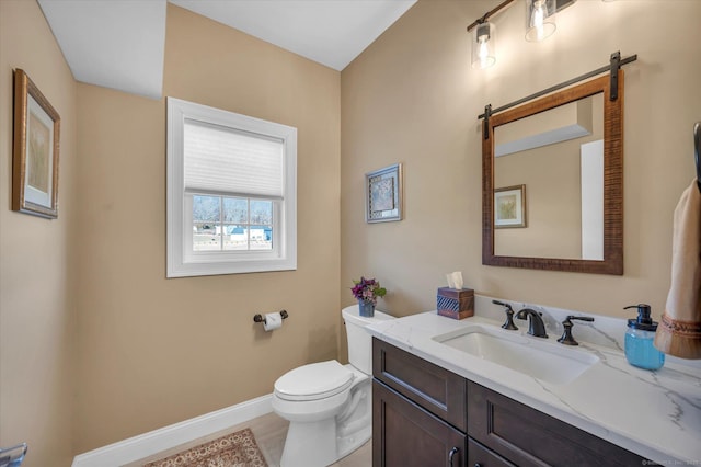 bathroom with toilet, hardwood / wood-style floors, and vanity