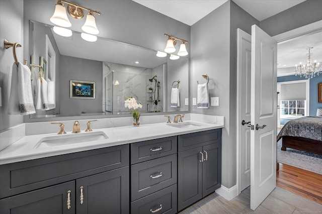 bathroom with vanity, an enclosed shower, and a chandelier