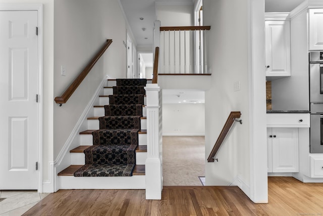 staircase with baseboards and wood finished floors