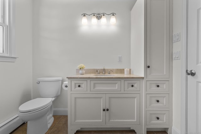 bathroom featuring toilet, a baseboard heating unit, tile patterned flooring, baseboards, and vanity