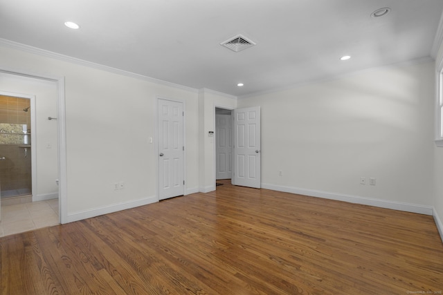 unfurnished bedroom with visible vents, wood finished floors, baseboards, and ornamental molding