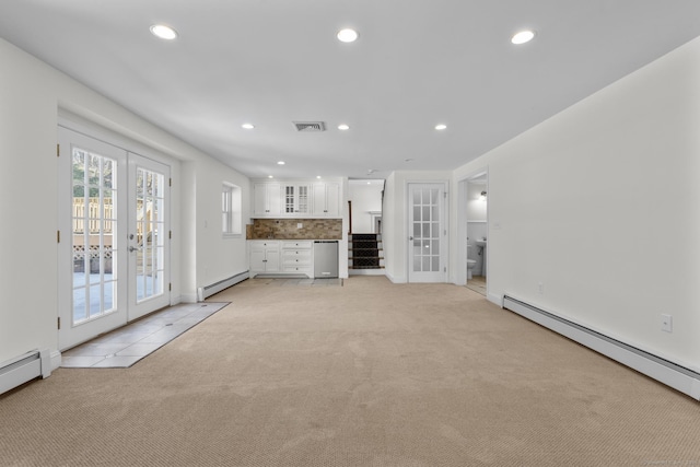 unfurnished living room with a baseboard heating unit, french doors, visible vents, and light carpet