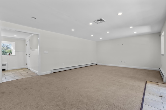 empty room with light carpet, visible vents, recessed lighting, and a baseboard heating unit