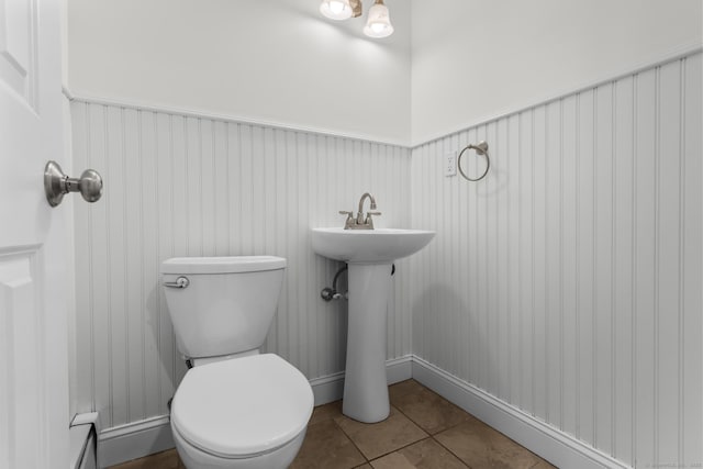 bathroom featuring tile patterned floors, a wainscoted wall, baseboard heating, and toilet