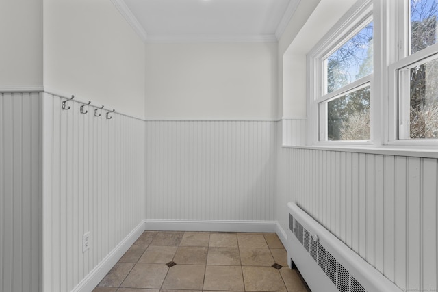 interior space with tile patterned flooring, a wainscoted wall, crown molding, and radiator heating unit