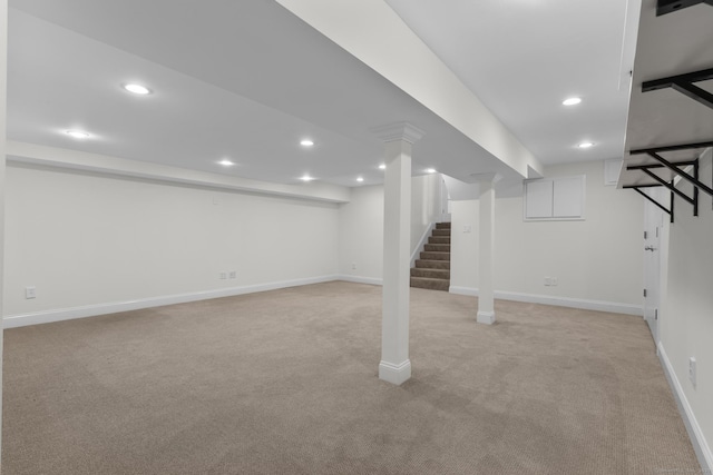 finished below grade area with stairs, recessed lighting, light colored carpet, and baseboards