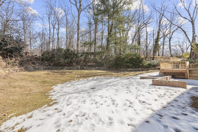 yard layered in snow with a wooden deck