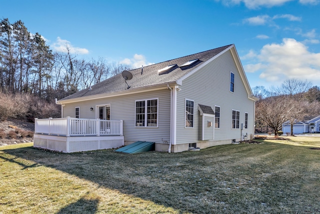 rear view of house featuring a wooden deck and a yard