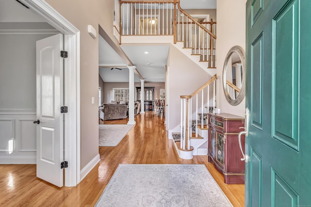 entrance foyer featuring light wood-type flooring and decorative columns