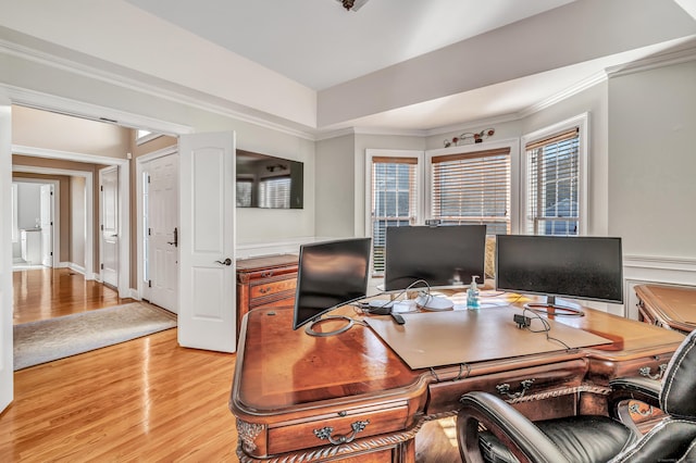 office space with a raised ceiling, crown molding, and light hardwood / wood-style flooring