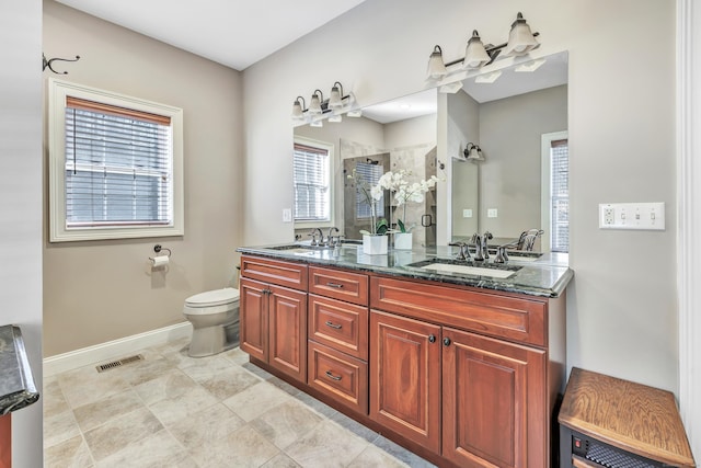 bathroom featuring vanity, toilet, an enclosed shower, and a wealth of natural light