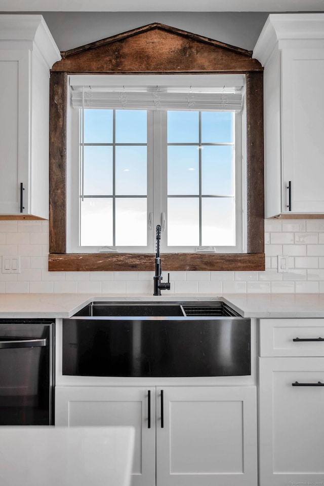 kitchen featuring white cabinets and dishwashing machine