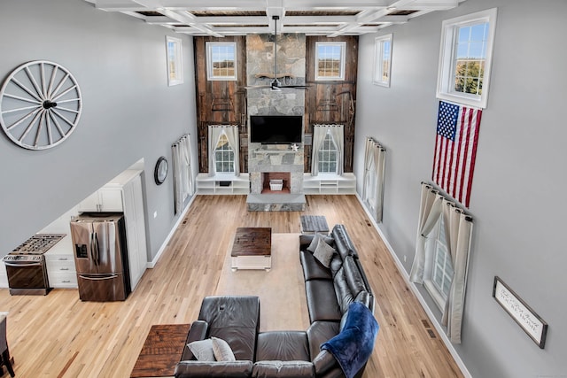 living room featuring beam ceiling, light hardwood / wood-style floors, and coffered ceiling