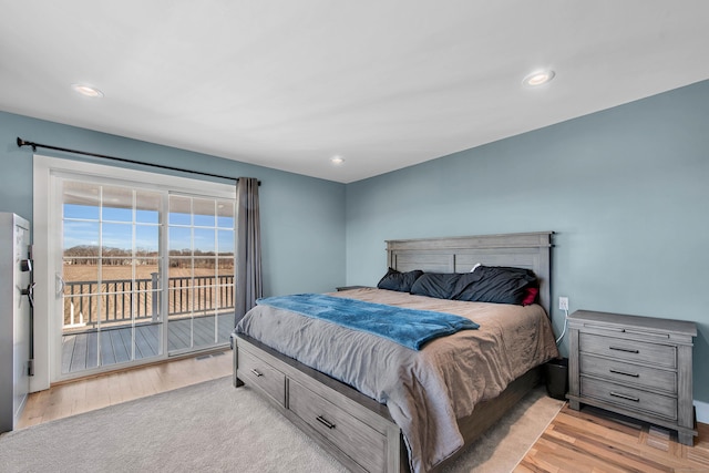 bedroom with access to outside and light hardwood / wood-style flooring