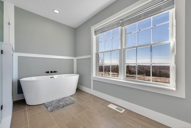 bathroom with a washtub and tile patterned flooring