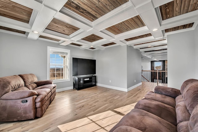 living room featuring coffered ceiling, ornamental molding, beamed ceiling, and light hardwood / wood-style flooring