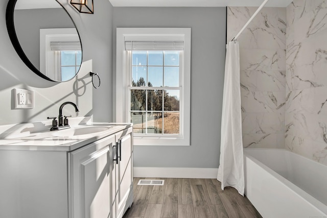 bathroom with hardwood / wood-style floors, vanity, and shower / bath combination with curtain